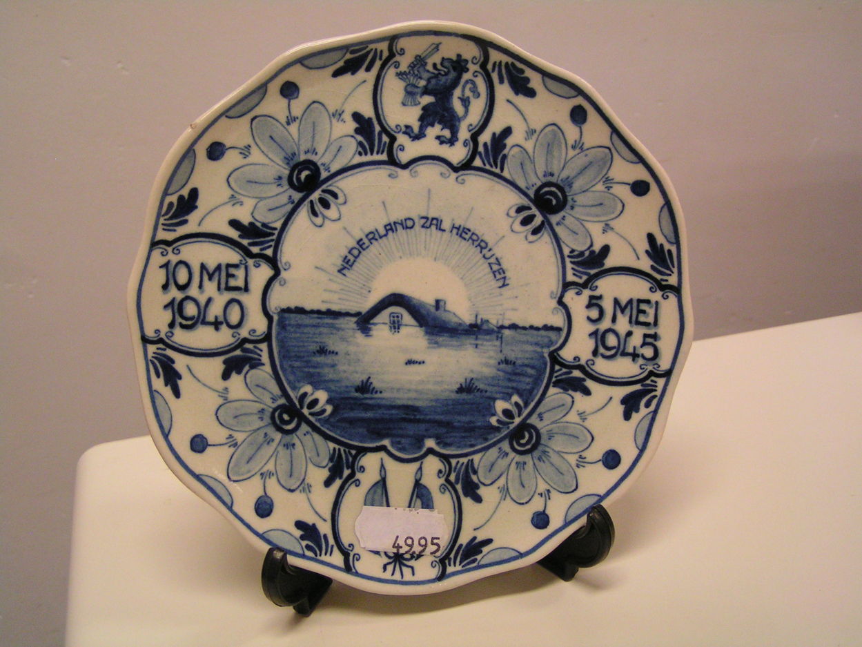 artikelnr. 00205 Wandtegeltje 'Nederland Zal Herrijzen" Regina Delftsblauw: prijs 49.95 euro
10 mei 1940
5 mei 1945
doorsnede: 16cm, ontv. G.A. Bonsel 573
Keywords: Wandtegeltje Nederland Delfstblauw Regina