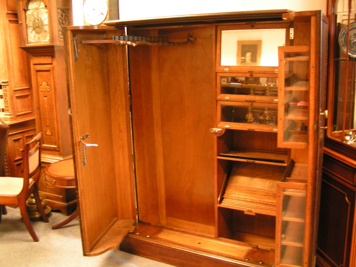 Verkocht 1600240 The Gentlemans Compacton - London: 
This piece of furniture is a mystery object. On the outside it looks very ordinary but on the inside it\'s like Aladdin\'s cave.
This Gentleman\'s Compactom resides at Bedervale, a historic home in Braidwood, NSW. The contents of Bedervale is from two families: six generations of the Cogal-Madrel family and the Royds family who moved here in 1973. All the contents that were owned by the Cogal-Madrel family are now owned by the National Trust, gifted by a grant from the National Estate. Bedervale is a living museum.
Victoria, accompanied by her mother Margaret Royds, took me on a tour of the house, sharing with me a few secrets of various objects at Bedervale.
The first object is a Gentleman\'s Compactom.
The Compactom wardrobe - also known as chiffarobe, chifferobe, wardrobe, armoire, dresserobe, closet and Gentleman\'s Butler - demonstrates how an object reflects upon the society that used it. Produced from the 1920s to the 1950s it illustrates how \'designers used wardrobe space to offer the supposed benefits of a tidy and orderly life in a period of rapid change\'. The wardrobe identifies a number of issues including concerns about efficiency, loss of domestic staff, clothes maintenance and middle-class identity\'. Viewed within the context of Bedervale you can see how apparent this was.
During the 1920s Compactoms were often acquired into the marriage when newlyweds started a home together. They were commonly sold as sets with the rest of the bedroom furniture, but could also be purchased individually.
Description:
The moulded cornice above a pair of panelled doors enclosing a well-fitted interior of hooks to the right and shelves and compartments to the left, some with glazed doors and others open, bearing labels reading \'Opera Hats\', \'Pyjamas\' and \'Dress Shirts\' etc., the doors with rails and further shelves, with a lidded compartment for \'Sundries\' in the plinth, 127cm wide x 56cm deep x 174cm high, (50\" wide x 22\" deep x 68.5\" high)
A gentleman\'s mahogany Compactom wardrobe, early 20th Century bearing label to interior reading \'Compactum...41 - 44 Upper Berkely St. London\' and retailer\'s label for \'Finnigans Ltd.\'
Keywords: The Gentlemans Compacton