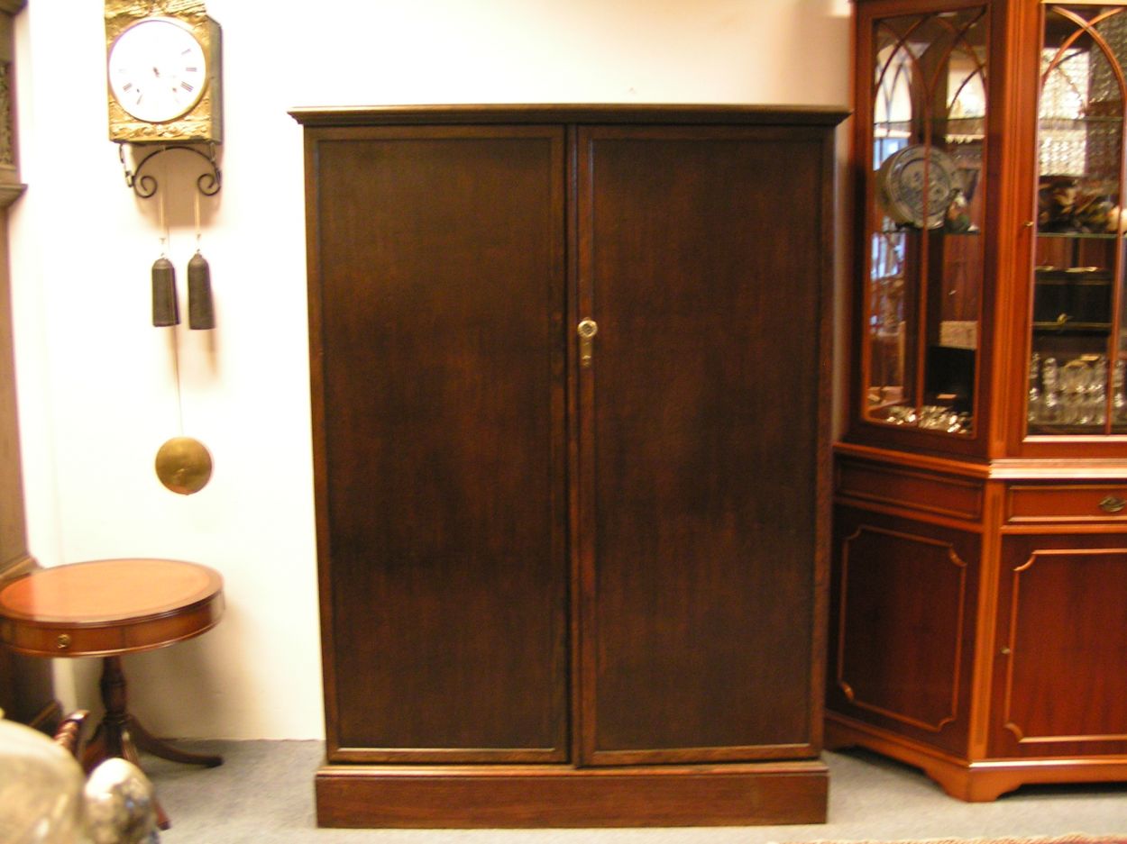 Verkocht 1600240 The Gentlemans Compacton - London:
This piece of furniture is a mystery object. On the outside it looks very ordinary but on the inside it\'s like Aladdin\'s cave.
This Gentleman\'s Compactom resides at Bedervale, a historic home in Braidwood, NSW. The contents of Bedervale is from two families: six generations of the Cogal-Madrel family and the Royds family who moved here in 1973. All the contents that were owned by the Cogal-Madrel family are now owned by the National Trust, gifted by a grant from the National Estate. Bedervale is a living museum.
Victoria, accompanied by her mother Margaret Royds, took me on a tour of the house, sharing with me a few secrets of various objects at Bedervale.
The first object is a Gentleman\'s Compactom.
The Compactom wardrobe - also known as chiffarobe, chifferobe, wardrobe, armoire, dresserobe, closet and Gentleman\'s Butler - demonstrates how an object reflects upon the society that used it. Produced from the 1920s to the 1950s it illustrates how \'designers used wardrobe space to offer the supposed benefits of a tidy and orderly life in a period of rapid change\'. The wardrobe identifies a number of issues including concerns about efficiency, loss of domestic staff, clothes maintenance and middle-class identity\'. Viewed within the context of Bedervale you can see how apparent this was.
During the 1920s Compactoms were often acquired into the marriage when newlyweds started a home together. They were commonly sold as sets with the rest of the bedroom furniture, but could also be purchased individually.
Description:
The moulded cornice above a pair of panelled doors enclosing a well-fitted interior of hooks to the right and shelves and compartments to the left, some with glazed doors and others open, bearing labels reading \'Opera Hats\', \'Pyjamas\' and \'Dress Shirts\' etc., the doors with rails and further shelves, with a lidded compartment for \'Sundries\' in the plinth, 127cm wide x 56cm deep x 174cm high, (50\" wide x 22\" deep x 68.5\" high)
A gentleman\'s mahogany Compactom wardrobe, early 20th Century bearing label to interior reading \'Compactum...41 - 44 Upper Berkely St. London\' and retailer\'s label for \'Finnigans Ltd.\'
Keywords: The Gentlemans Compacton